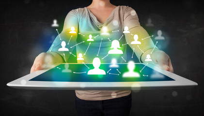 Young person presenting tablet with green social media icons