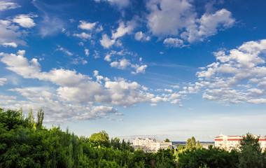 Fototapeta na wymiar Sky with clouds on a background of trees and buildings
