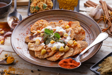 indian streetfood papri chaat garnished and served with yoghurt