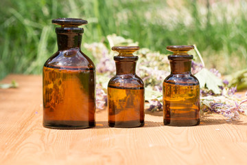 essential oil in little bottle and medical flowers herbs