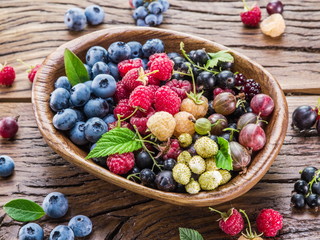 Ripe berries in the wooden bowl.