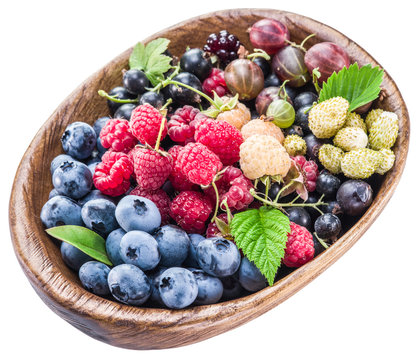 Berries in the wooden bowl on a white.