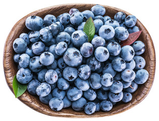 Ripe blueberries in the wooden bowl.