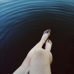 female legs near still water