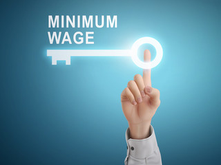 male hand pressing minimum wage key button