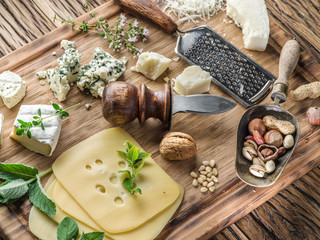 Fototapeta na wymiar Different types of cheeses with nuts and herbs.