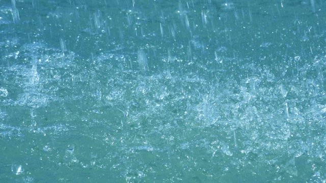 Heavy rain falling on water surface, water drops element shot, 4k uhd footage