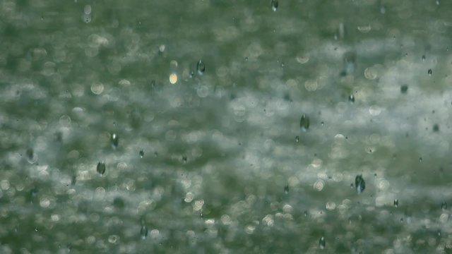 Heavy rain falling on water surface, water drops element shot, hd footage, slow motion