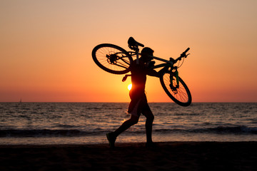 ride at sunset with bike on his shoulders