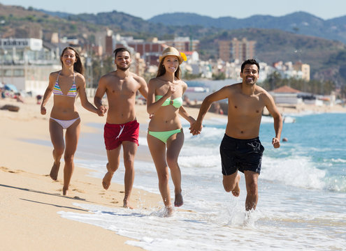 Adults running at sandy beach
