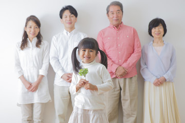 Obraz na płótnie Canvas 苗を持つ女の子と家族