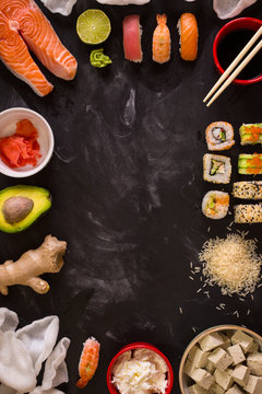 Sushi and ingredients on dark background