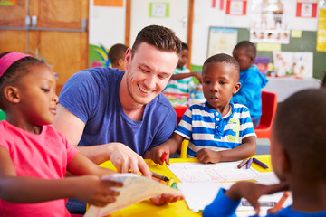 Volunteer teacher sitting with preschool kids in a classroom