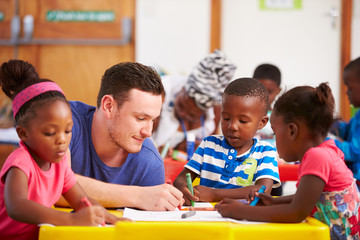 Volunteer teacher sitting with preschool kids in a classroom