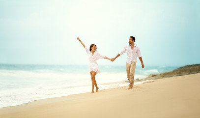 laughing couple in love holding hand  on beach