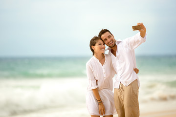 couple on the beach taking photo of themselves