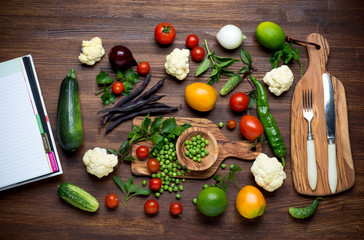 Healthy food. Herbs and vegetables on wooden table with recipe