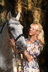 Obraz premium Beautiful blonde woman with a horse