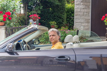 Classy senior sportsman driving cabriolet car