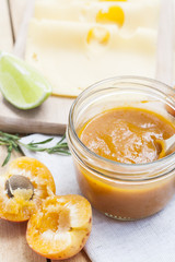 Homemade apricot jam and fresh apricots with leaves on the wooden table