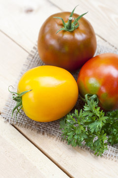 Assorted tomatoes: orange, pink, black tomatoes with parsle
