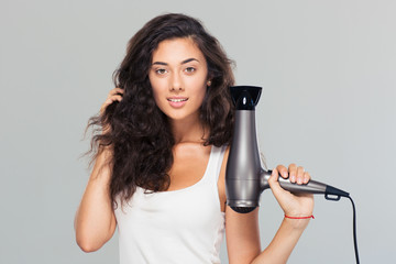 Happy beautiful woman holding hairdryer