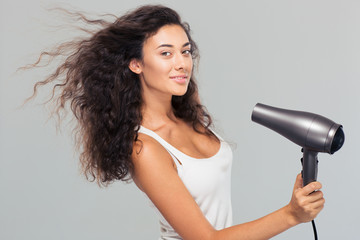 Smiling young woman dries her hai