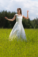 Naklejka na ściany i meble young girl in a wedding dress dancing