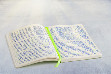 Open notebook with handwritten  lorem ipsum text and ribbon book