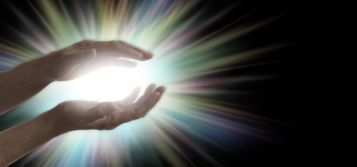 Miracle maker - pair of parallel female healer's hands with a bright white and rainbow colored...