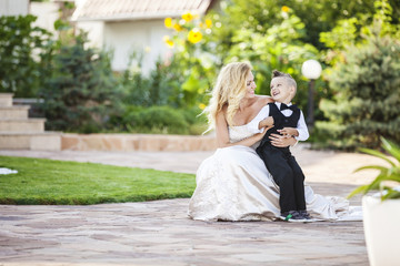 Happy bride and smiling little boy outdoors