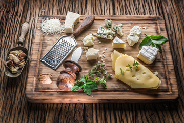 Different types of cheeses with nuts and herbs.