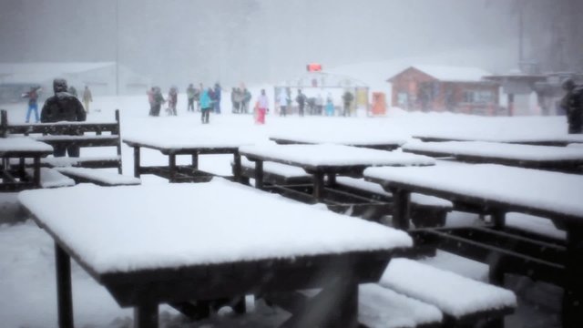 Chairs and table made from snow at Ski bar during snowfall in