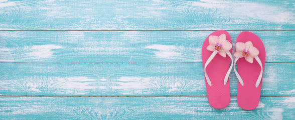 Summer vacation. Pink sandals by swimming pool.