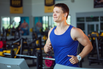 Fototapeta na wymiar Man running on the treadmill in the gym