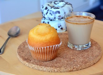 Cup of coffee with muffin on a table