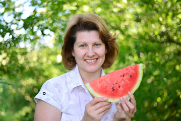 Woman with slice of watermelon in nature