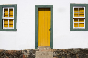 Colonial House With Yellow and Green Door and Windows - Historic