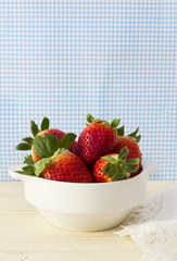 Fresh and deliciuos strawberries on a white bowl.