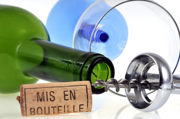 Bouteille de vin et verre vides près d'un tire-bouchon