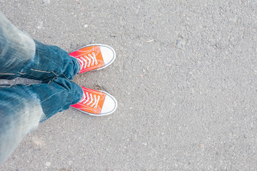 young man feet in red sneakers on cobbled road
