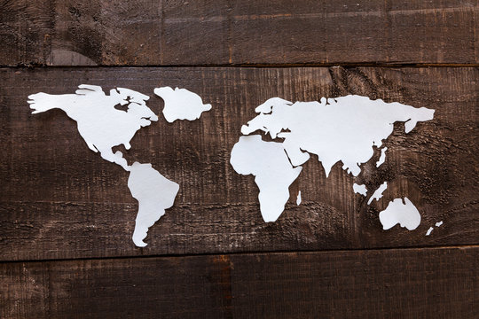 Photo illustration showing the world in wood background and paper