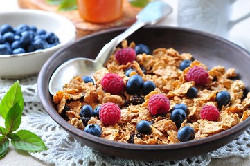 homemade granola with fresh blueberries, raspberries, raisins, milk and honey. Healthy Breakfast