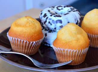 Homemade delicious muffins and donuts on a plate on a table.