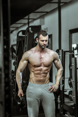 Fototapeta na wymiar Man posing in gym showing abs