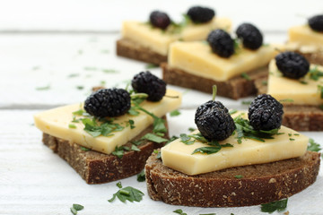 wood background sandwich with cheese and mulberry
