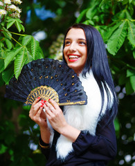 Smiling young woman and flower with ornamental fan and wolf fur