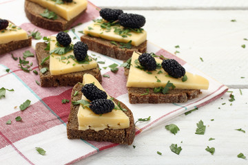 wood background sandwich with cheese and mulberry