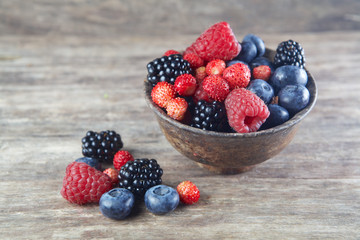 Assorted berries in bowl on wood