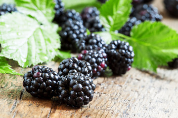 Fresh blackberries with leaves on the old wooden background, sel